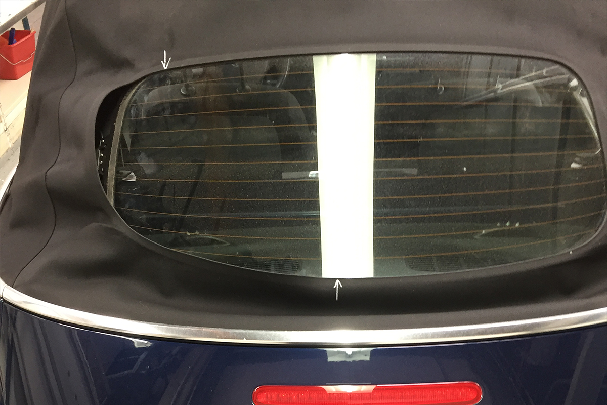 Gelöste Glasheckscheibe an blauem Cabrioverdeck